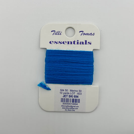 Tilli Tomas Essentials needlepoint thread, in blue jet ski 694.  50% silk, 50% merino wool, 10 yards wound on a white cardboard card.