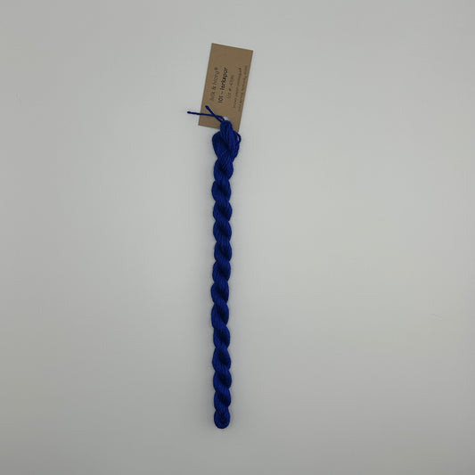 30 yard skein of silk & Ivory in the color 101 Larkspur with brown tag laying flat on white background