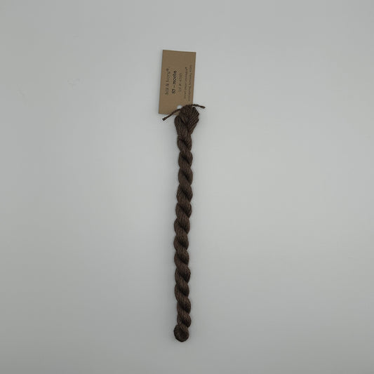 30 yard skein of silk & Ivory in the color 85 Mocha with brown tag laying flat on white background