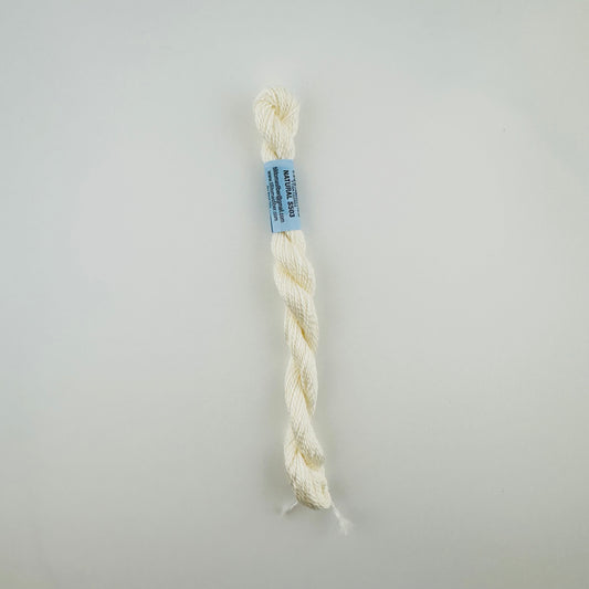 30 yard skein of essentials needlepoint thread in Natural S503, with blue label lying flat on white background