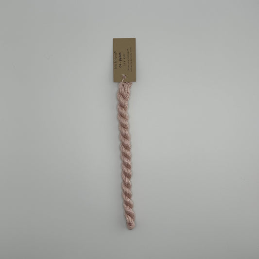 30 yard skein of silk & Ivory in the color 04 Peach with brown tag laying flat on white background