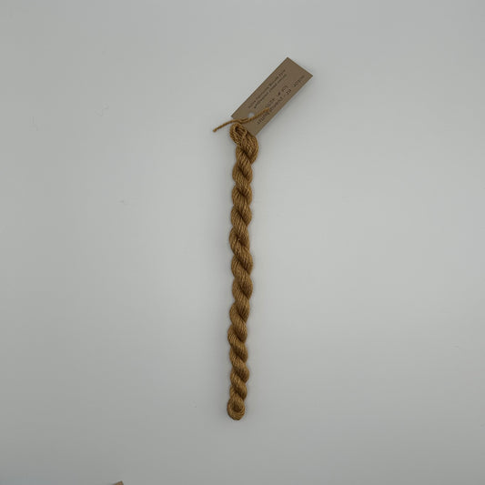 30 yard skein of silk & Ivory in the color 67 Peanut Butter with brown tag laying flat on white background