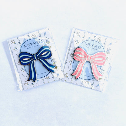 two magnetic needle minder. one pink and one blue by Navy Noo, displayed on its branded white backing card inside a clear plastic sleeve, set against a clean white background.