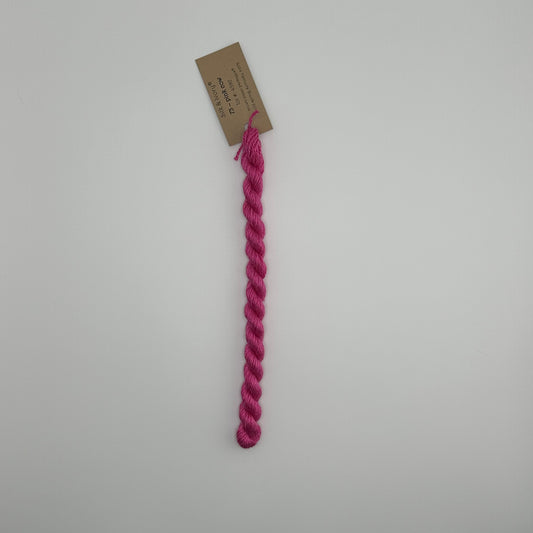 30 yard skein of silk & Ivory in the color 73 Pink Cow with brown tag laying flat on white background