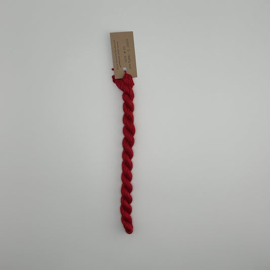 30 yard skein of silk & Ivory in the color 11 Really Red with brown tag laying flat on white background