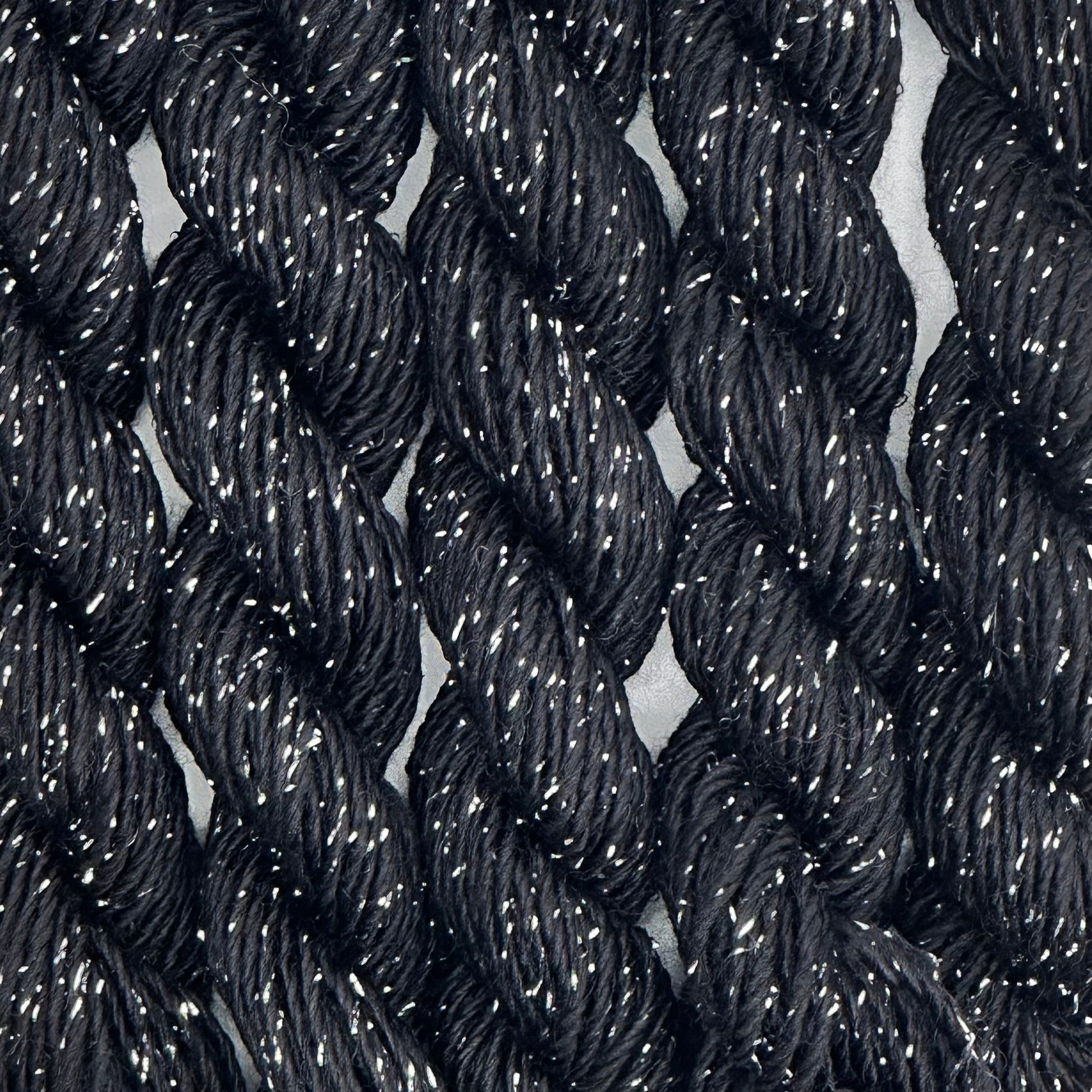 close-up of 6 skeins of Stardust Silk and Ivory needlepoint thread in black 512, lying side by side.