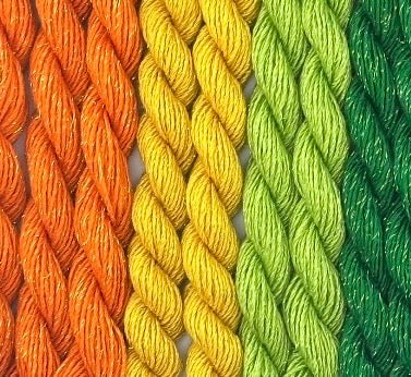 close-up of 8 skeins of Stardust Silk and Ivory needlepoint thread in three colors including orange marmalade 716, yellow marigold 615, green margarita 594, and green emerald 525, lying side by side.