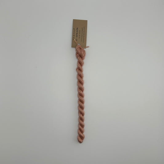 30 yard skein of silk & Ivory in the color 21 Terra Cotta with brown tag laying flat on white background