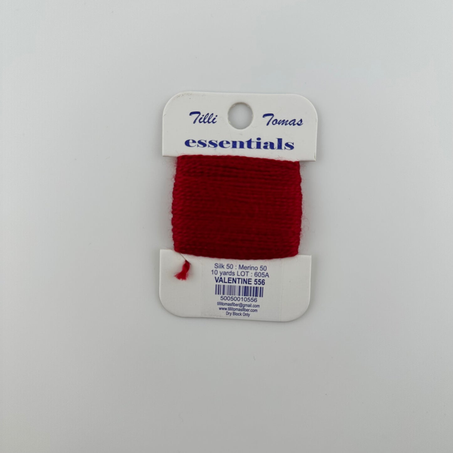 Tilli Tomas Essentials needlepoint thread, in red valentine 556.  50% silk, 50% merino wool, 10 yards wound on a white cardboard card.