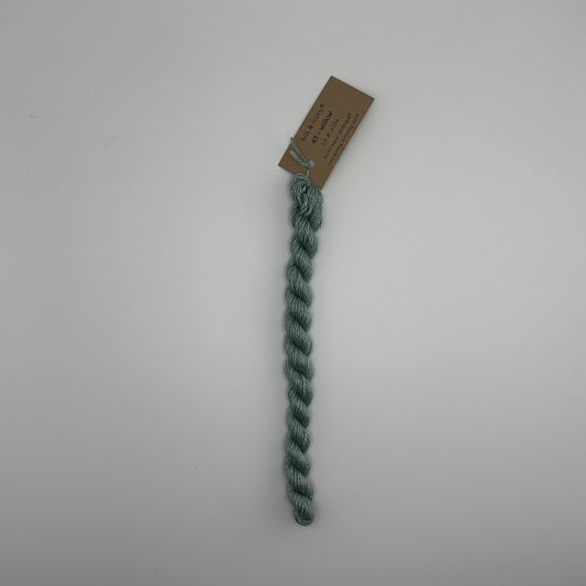 30 yard skein of silk & Ivory in the color 45 Willow with brown tag laying flat on white background